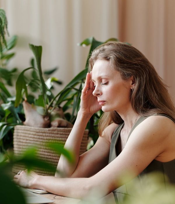 Person gently touching their temples, showing a sense of relief and calm.